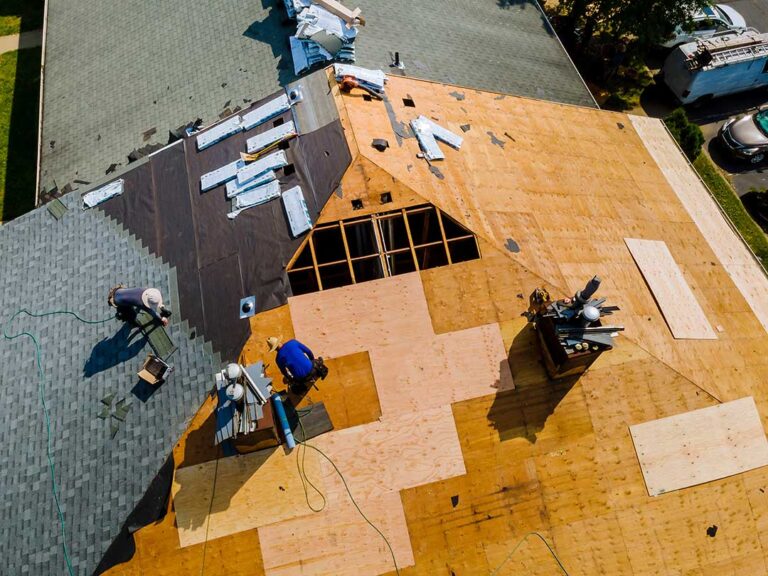 Homeowners sort asphalt shingles, metal flashing, and wood roofing debris into separate covered containers.